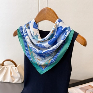 Detail of blue and white beetle print silk scarf tied on black top with luxury wooden hanger