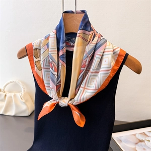 Détail d'un foulard en soie à motif géométrique sur cintre avec sac à perles