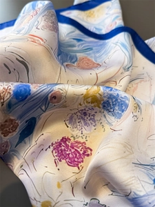 Dettaglio del foulard di seta con motivi a pittura a olio ed eleganti bordi blu rifiniti