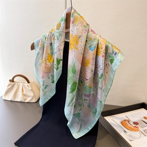 Elegante foulard quadrato in seta con motivi floreali e bordo verde, stile raffinato