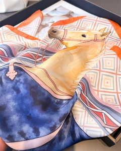 Gros plan d'un foulard en satin de luxe avec motif tête de cheval et dessins géométriques