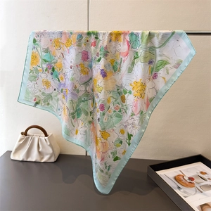 Dettaglio di un foulard di seta a fiori appeso per mostrare la caduta del tessuto