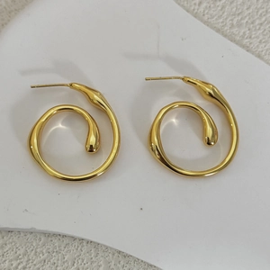 Close-up of gold plated spiral earrings with a minimalist streamlined water-drop design