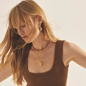 Ensemble collier et boucles d'oreilles goutte d'eau dorés 18K sur mannequin style épuré
