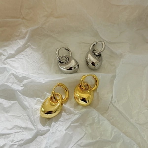 Boucles d'oreilles goutte d'eau en or 18 carats et argent sur papier blanc texturé