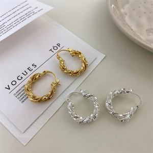 Close-up of twisted rope texture double hoop earrings in gold and silver finish