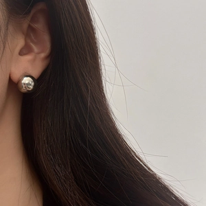 Minimalist silver mirror polished sphere stud earrings for women on a model