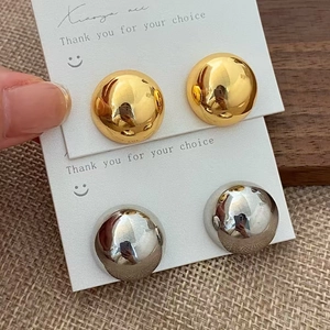 Minimalist gold and silver dome stud earrings with high-polish mirror finish on a card