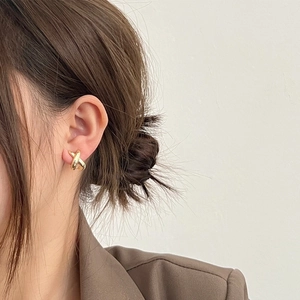 Close-up of minimalist gold-plated cross line stud earrings on model for a chic look