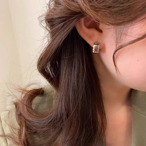 Minimalist silver C-shaped geometric stud earrings with polished finish on female model