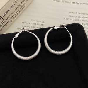 Macro shot of silver matte texture on large geometric hoop earrings with S925 pins