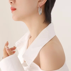 Minimalist silver U-shaped hollow earrings with a polished finish on a model