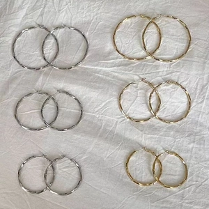Détail de six paires de créoles torsadées en finitions or et argent et trois tailles