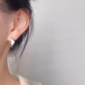 Polished silver geometric rhombus hoop earrings on model for a minimalist fashion look