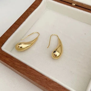 Polished 18K gold-plated teardrop hollow earrings in a white velvet wooden jewelry box