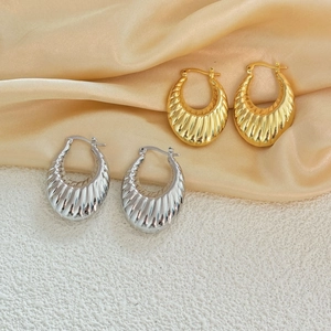 Boucles d'oreilles créoles croissant en or 18K et argent avec texture sur fond de soie