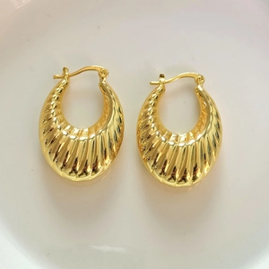 Gros plan sur des boucles d'oreilles croissant dorées avec détails de texture spirale