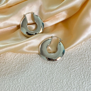 Créoles épaisses en argent poli avec finition métal liquide sur fond en satin doux