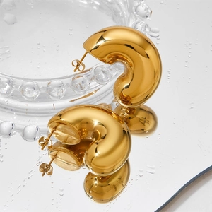 Boucles d'oreilles créoles épaisses en C plaquées or 18 carats sur surface réfléchissante