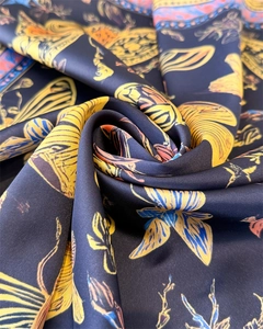Detail of silk-like scarf showing vibrant butterfly floral prints on black satin fabric
