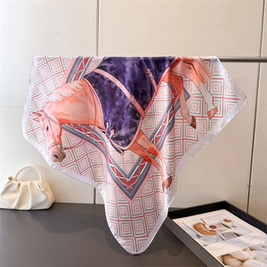 Gros plan détaillé d'un foulard en soie avec motifs de chevaux et dessins géométriques