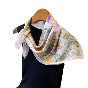 Foulard tipo seta con stampa floreale appeso sopra un top nero senza maniche