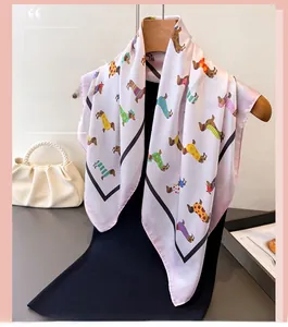 Détail d'un foulard en soie rose avec motif teckel suspendu à un cintre en bois