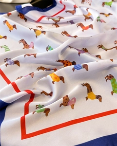 Vue détaillée d'un foulard carré en soie avec des imprimés teckels et texture satinée