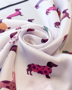 Vue rapprochée d'un foulard en soie blanche avec motifs teckels et texture satinée