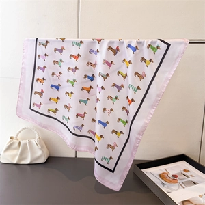 Gros plan d'un foulard en soie satinée avec motifs teckels et bordures roses