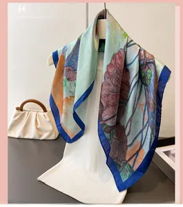 Detail of silk-like scarf with floral lotus pattern and royal blue edges on a mannequin