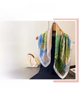Detail showing high-quality silk scarf texture with elegant lotus prints and hemmed edges