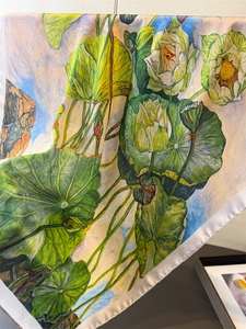 Close-up of artistic lotus print silk scarf with detailed green leaves and white petals