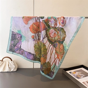 Detailed drape of a silk-feel scarf featuring artistic lotus floral prints and fine edges