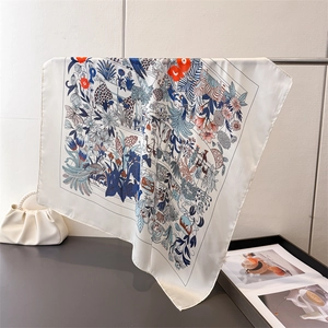 Dettaglio foulard in seta con stampe floreali e animali in blu notte e rosso vivo
