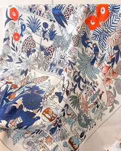 Dettaglio del foulard in seta con motivi artistici di animali della foresta e piante