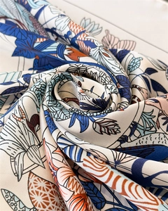 Vista dettagliata della trama lussuosa in seta con vivaci motivi floreali artistici