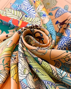 Dettaglio di un foulard in seta con stampe tropicali della giungla e motivi floreali