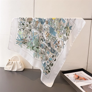 Dettaglio ravvicinato di foulard quadrato in finta seta bianca con stampa floreale
