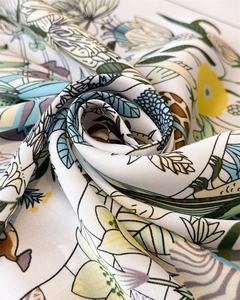 Vista dettagliata del tessuto in seta morbida con eleganti stampe floreali e motivi di gigli