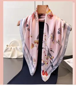 Detailed view of floral print silk scarf with artistic watercolor patterns and grey borders