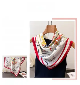Detail showing vintage floral print silk scarf with elegant red border and creamy satin finish