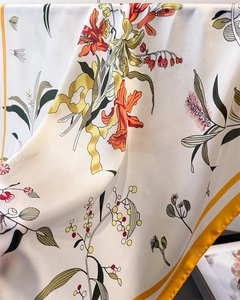 Close-up of floral print silk scarf showing soft drape and vibrant botanical patterns
