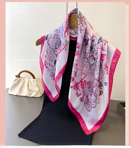 Detailed view of elegant silk scarf with floral patterns on a wooden hanger with handbag