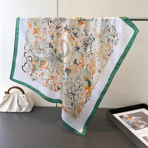 Silk-feel square scarf with jungle nature print and green borders on display stand