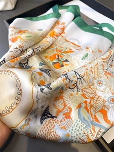 Detail of silk scarf with tropical bird and floral patterns in an elegant gift box