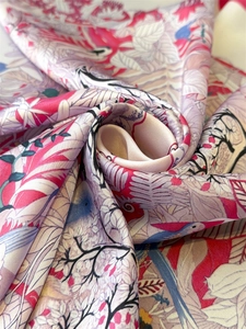 Close-up of printed silk square scarf with floral and tropical bird patterns and satin sheen