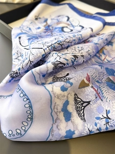 Detail of silk scarf with floral bird print in elegant lavender and blue shades