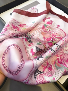 Detailed view of the silky tropical floral scarf with colorful bird print and contrast hem
