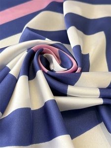 Close-up of silk-like satin fabric with navy blue white and pink striped pattern texture